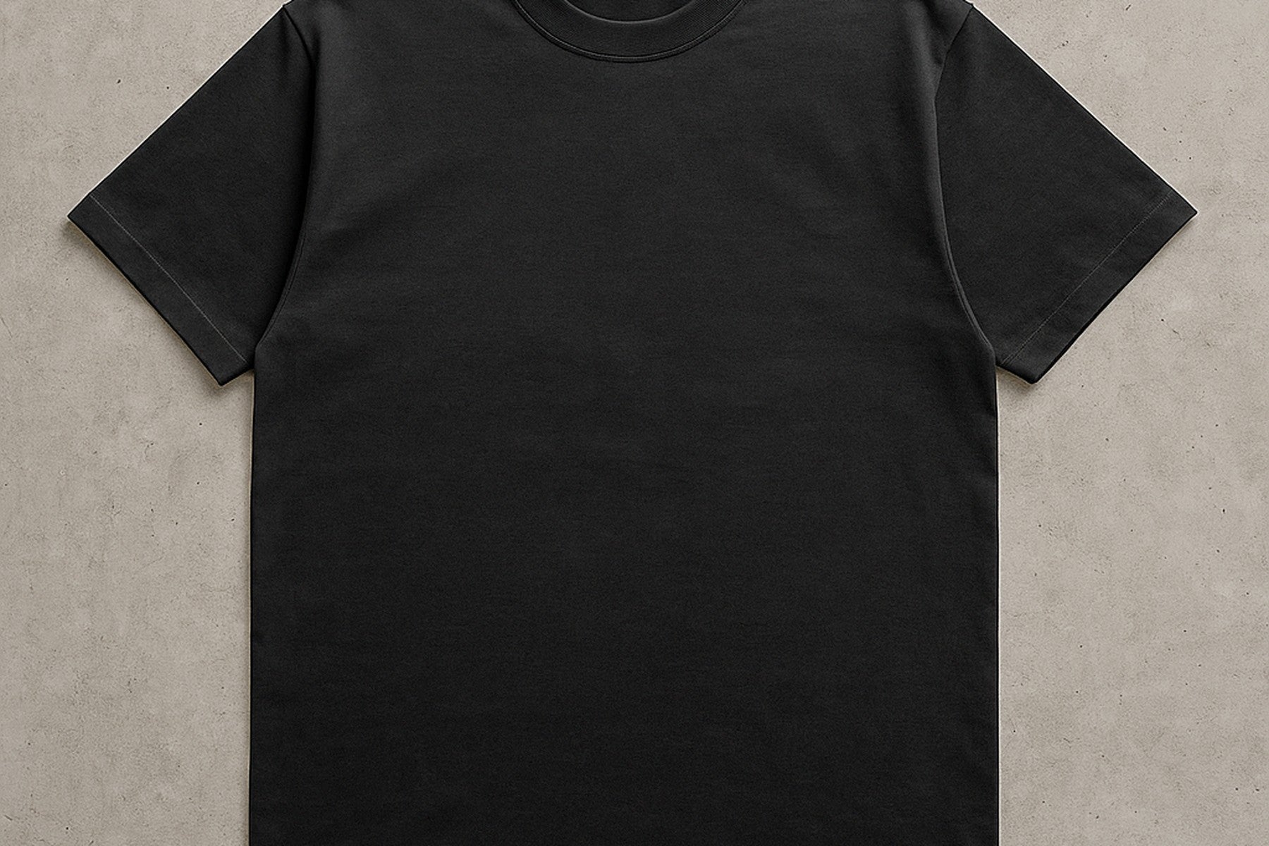 Blank black tee laid flat on concrete